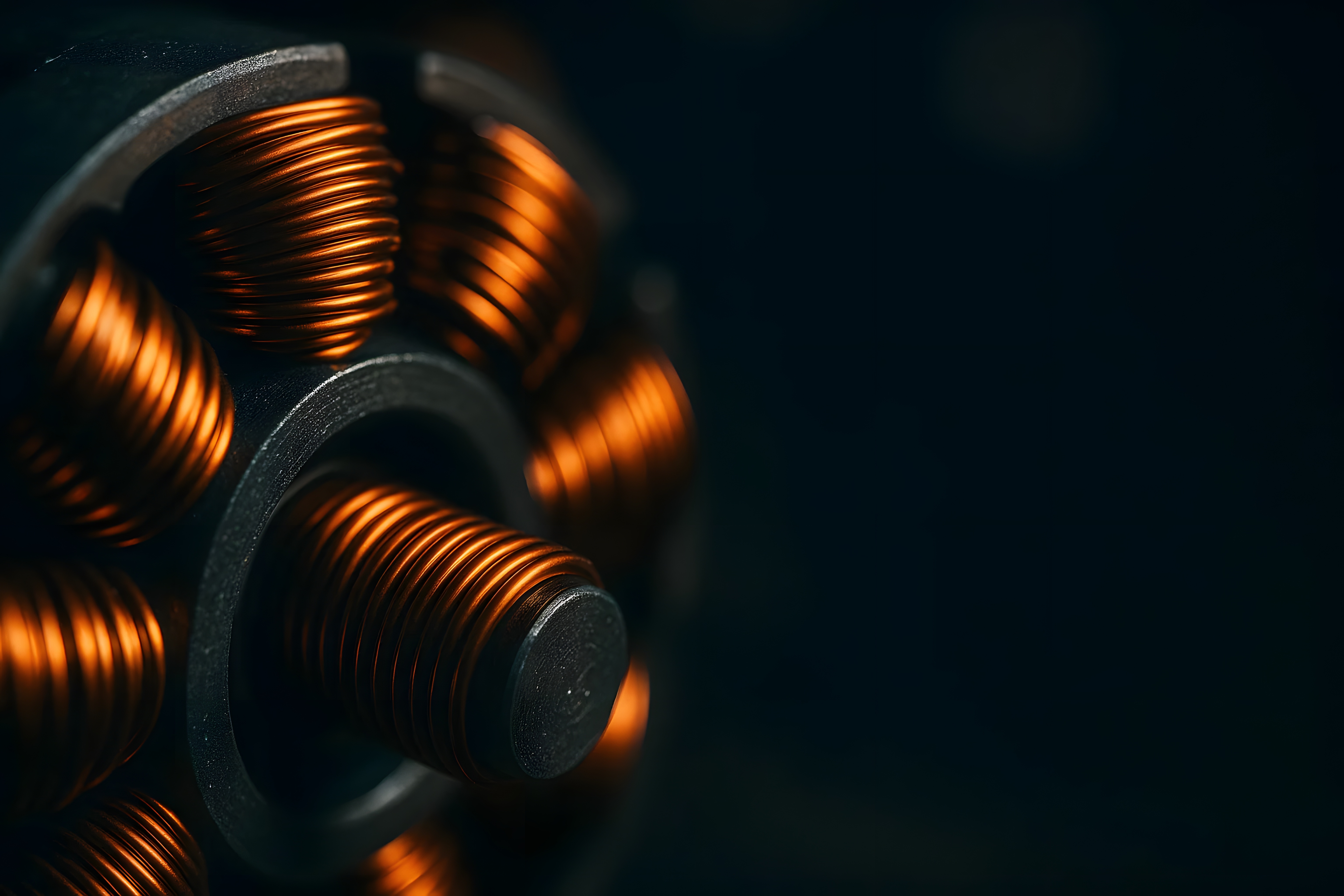 Macro photograph of copper coils with warm metallic glow on a dark background